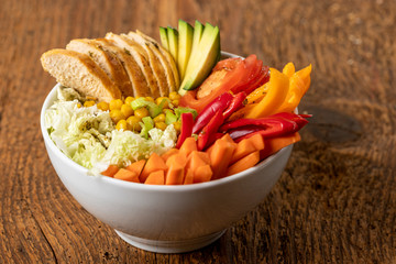buddha bowl with chicken on wood