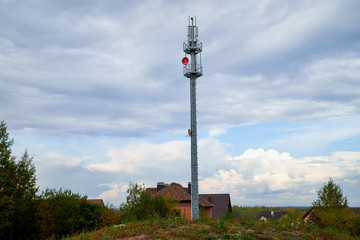 Obraz premium High tower for cellular communication, signal transmission, energy on the background of blue sky with clouds