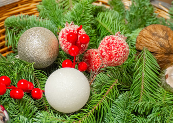 Christmas composition of fir branches, coconut, red berries and balls in a basket. Christmas and New Year background