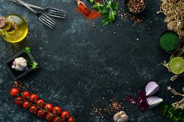 Food banner. Spices, vegetables and herbs on a black stone background. Top view. free space for your text. Rustic style.