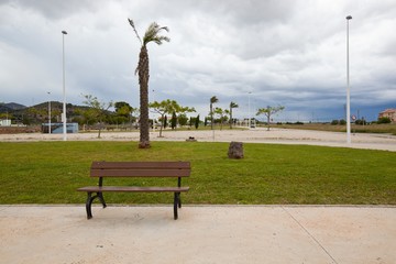 Obraz premium Bench in park with stormy sky, Valencia region, Spain