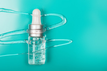 Bottle with hyaluronic acid on bright, background. Concept of modern beauty. Flat lay style.