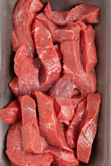 sliced raw meat in plastic box