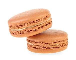 Close up of two sweet caramel French macaroons isolated on white background