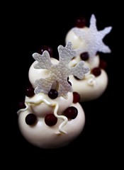 White christmas tree mousse desserts with cranberries and white chocolate snowflake decorations
