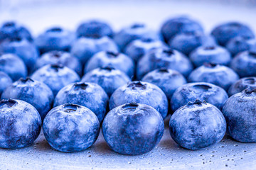 Selective focus on a heap of blueberries at the concrete background. Closeup view. 