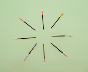 Makeup brush with a sun shape, on a green paper background