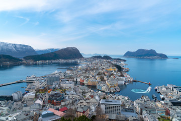 Fototapeta premium birds eye, aerial view over scandinavian city of Alesund and Harbor with a beautiful sight of the fjord of Alesund on a sunny day in spring with blue skies