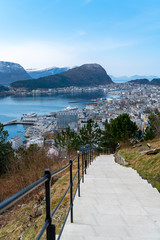 birds eye, aerial view over scandinavian city of Alesund and Harbor with a beautiful sight of the fjord of Alesund on a sunny day in spring with blue skies