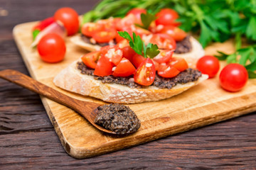 Fresh tasty bruschetta with truffle sauce, chili, parsley, tomates. Close view
