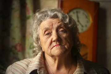 Elderly sad woman looking and thoughtful face on a dark background