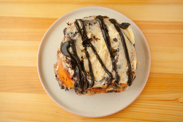 roll with cinnamon on a plate on  wooden background