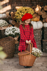 Portrait of a beautiful little girl with bright flowers in autumn gazebo