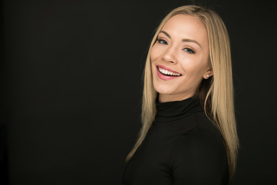 Beautiful portrait of laughing blond woman on a black background
