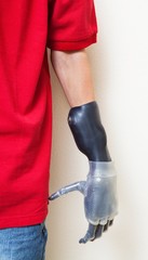 Cropped image of man with prosthetic hand over gray background