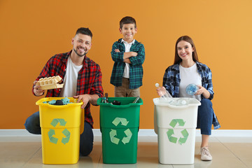 Family with containers for garbage on color background. Concept of recycling