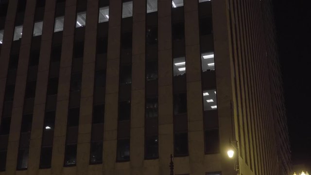 typical night time exterior establishing shot of generic office building structure in big urban city skyline. Modern architecture construction