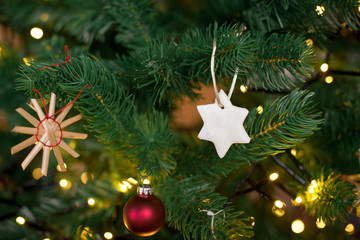christbaumanhaenger stern selbstgemacht aus salzteig im weihnachtsbaum haengend querformat