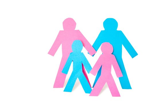Conceptual image of paper cut outs representing family with two children over white background
