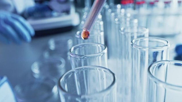 Pharmaceutics Laboratory: Pipette Dropping Liquid into Test Tubes, Medical Research and Analysis. Product Line; Dropper Fills Sample Tubes with Biochemical Fluid used for DNA Study. Close-up Macro