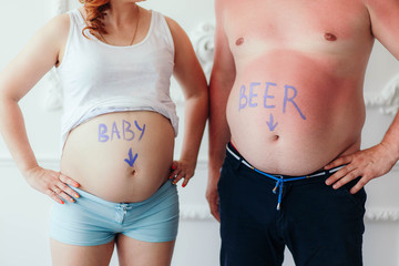 pregnant woman and man with beer belly