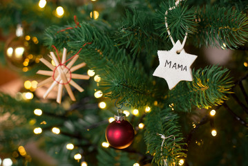 christbaumanhaenger selbstgemacht aus salzteig mit der aufschrift mama im weihnachtsbaum haengend querformat