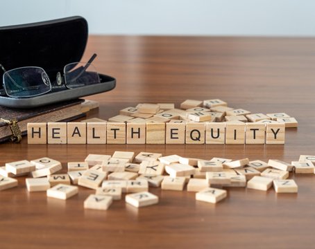 health equity the word or concept represented by wooden letter tiles