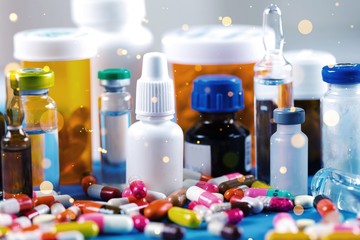 Colorful pills and tablets with bottles on background