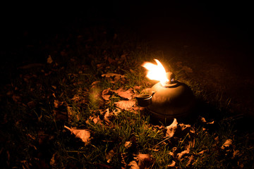 An oil lamp flaming during the night.