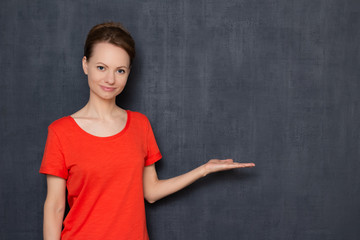 Portrait of happy girl pointing with hand at copy space on right