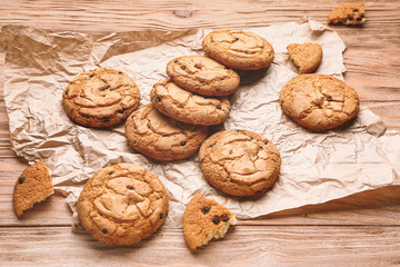 Tasty cookies with chocolate chips on wooden background