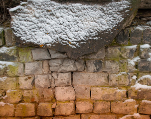 background, texture - wall of rough stonework, partly covered with snow