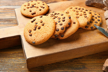 Tasty cookies with chocolate chips on wooden background