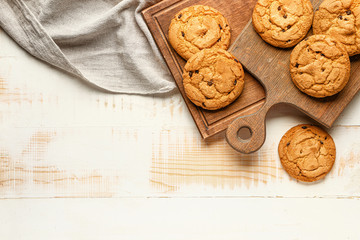 Tasty cookies with chocolate chips on wooden background