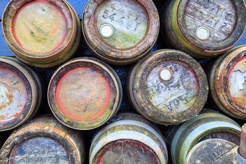 Vintage colorful wooden beer barrels, dumped and weathered.