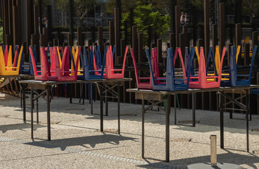 colored chairs on the table of a street cafe on a sunny day in the office district