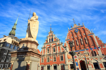 House of the Blackheads (Melngalvju nams) - historical building on Town Hall Square in Riga, Latvia, with St. Roland statue (1896.), under a blue sky with an interesting pattern of high cirrus clouds.