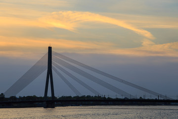 Silhouette of the Vansu Bridge (Latvian: Vansu tilts), a cable-stayed bridge that crosses the Daugava river in Riga, the capital of Latvia, and passes over Kipsala island, at sunset.