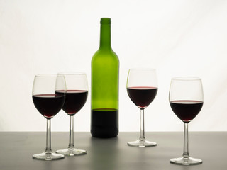 Close up of red wine glasses with a bottle of red wine