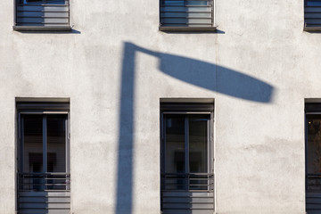 Fototapeta na wymiar Shadow of a street light on the white facade of a modern building.