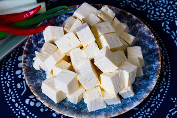 Sliced tofu cubes in a plate with soy bean on the side