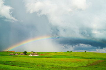 Rural landscape with rain clouds and a rainbow