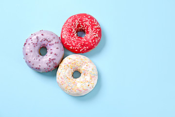 Sweet tasty donuts on color background
