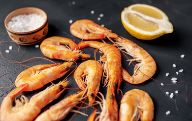 raw prawns waiting for the grilled cook, with herbs and spices on a stone background