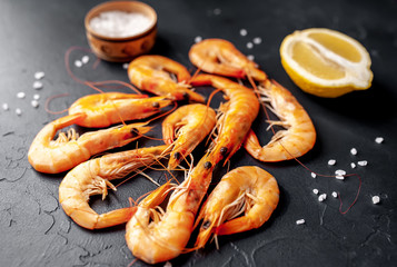 raw prawns waiting for the grilled cook, with herbs and spices on a stone background