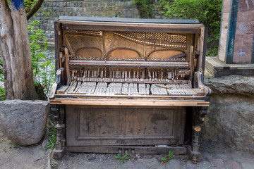 Dumped and damaged vintage upright piano with the internal parts partially exposed. © Predrag Jankovic