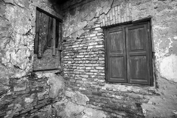 Fototapeta na wymiar Crumbling facade and walls of a ruin. Monochrome image.