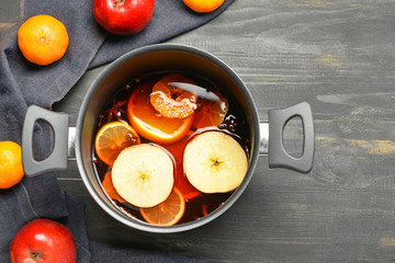 Pot with tasty mulled wine on table