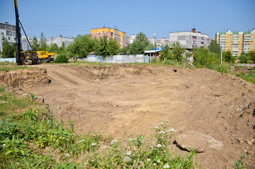 Foundation pit, construction of a new residential building of the city. Summer, sunny day and blue...