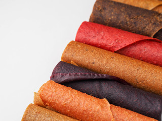 Colorful fruit leather rolls on white background